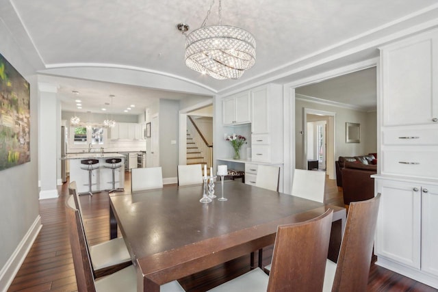 dining space with lofted ceiling, stairway, dark wood-type flooring, a chandelier, and baseboards