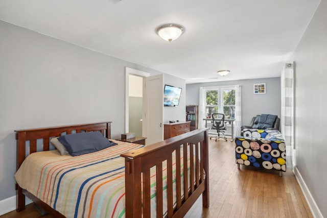 bedroom featuring hardwood / wood-style flooring and baseboards