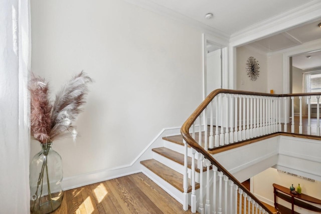 staircase with baseboards, wood finished floors, and crown molding