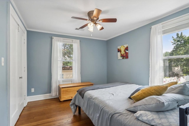 bedroom featuring baseboards, ceiling fan, dark wood-type flooring, and crown molding