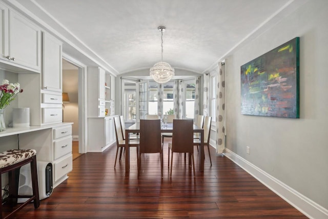 dining room featuring lofted ceiling, a notable chandelier, dark wood finished floors, and baseboards