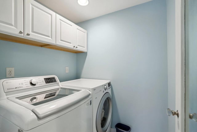 washroom with cabinet space and washer and dryer