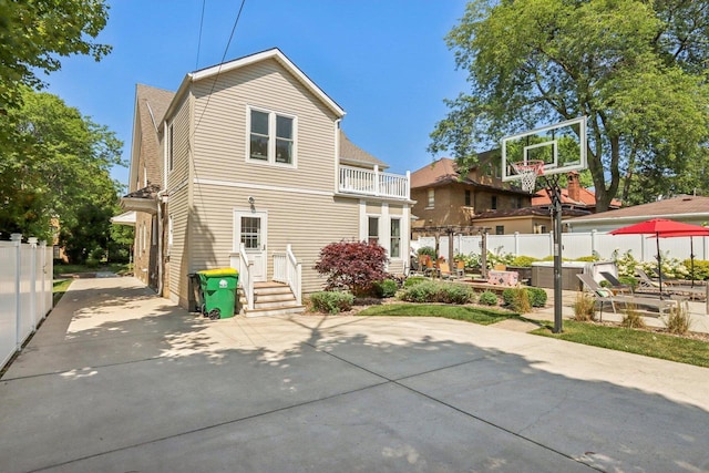 back of house with a balcony, fence, and a patio