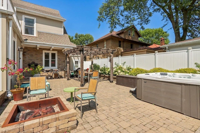 view of patio featuring an outdoor fire pit, a hot tub, a fenced backyard, a pergola, and outdoor dining space