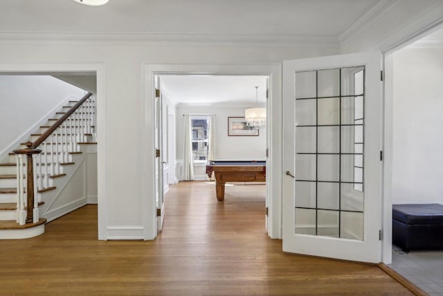 corridor with stairway, ornamental molding, and wood finished floors