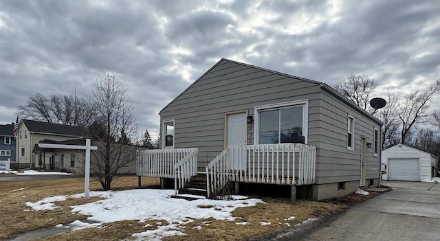 view of front facade featuring a garage, driveway, and an outbuilding