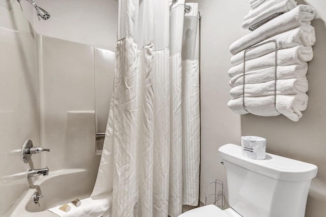 bathroom with shower / tub combo with curtain and toilet