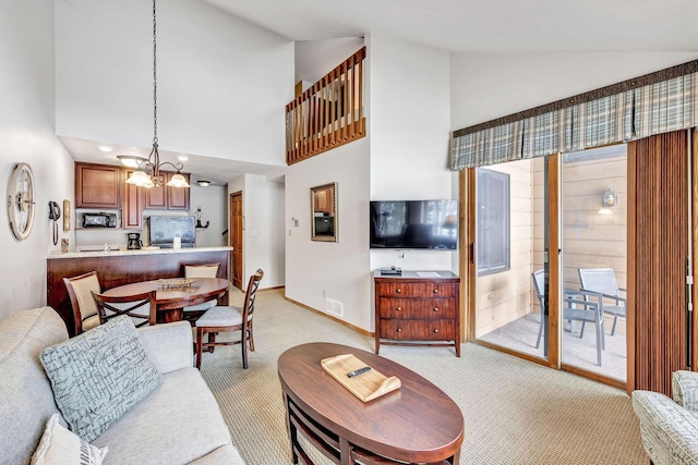 living area featuring light carpet, high vaulted ceiling, an inviting chandelier, and baseboards