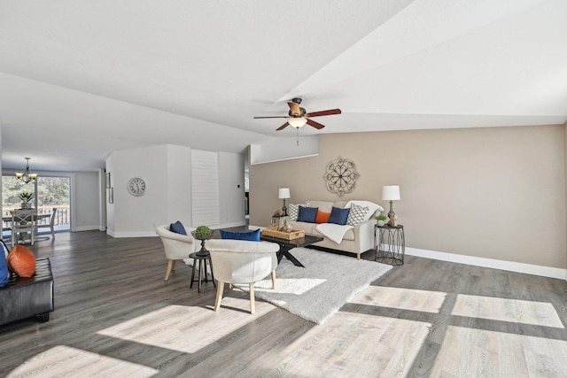 living room featuring lofted ceiling, baseboards, and wood finished floors