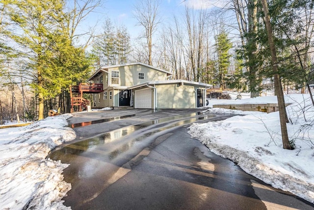 view of front of house with a garage, stairway, and aphalt driveway