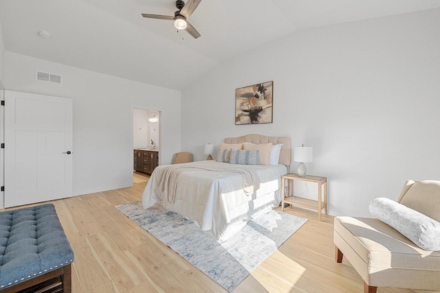 bedroom featuring visible vents, light wood-style floors, a ceiling fan, connected bathroom, and vaulted ceiling