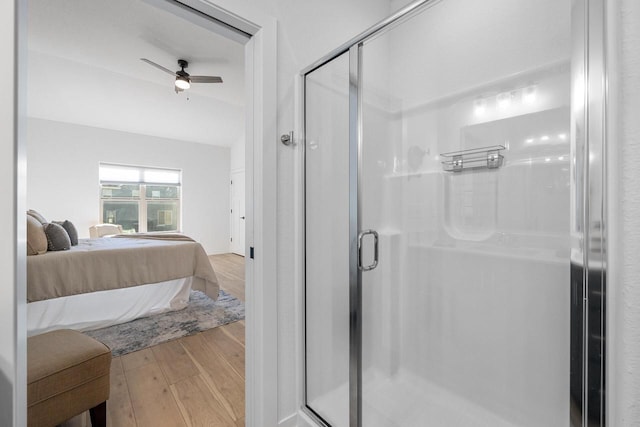 full bathroom featuring ceiling fan, a shower stall, ensuite bath, and wood finished floors