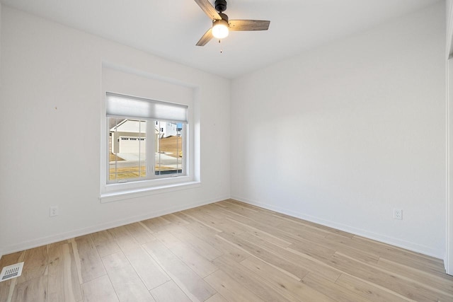 unfurnished room featuring light wood finished floors, baseboards, visible vents, and a ceiling fan