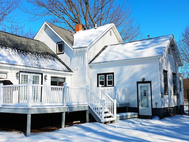 snow covered property with a wooden deck