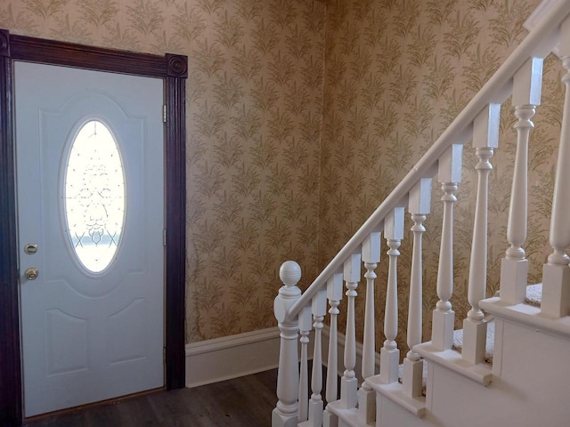 foyer entrance with baseboards, dark wood-type flooring, stairs, and wallpapered walls