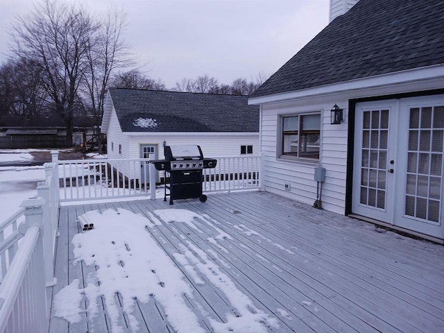 snow covered deck with french doors and grilling area