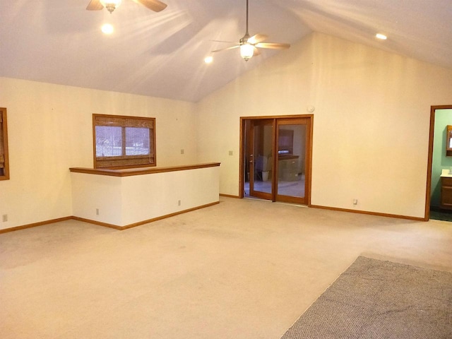 spare room with carpet floors, baseboards, vaulted ceiling, and a ceiling fan