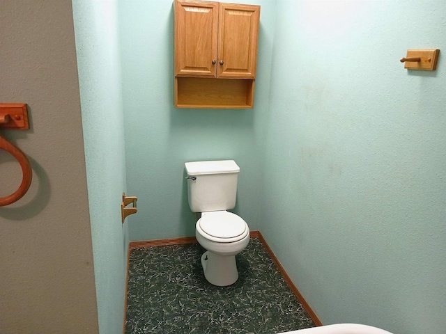 bathroom with toilet and baseboards