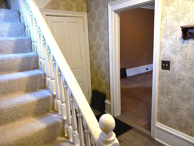 stairway featuring baseboards and wallpapered walls