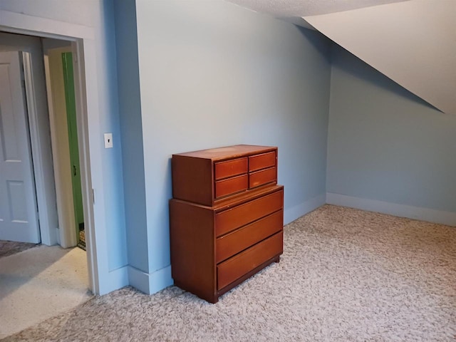 additional living space featuring light carpet and vaulted ceiling