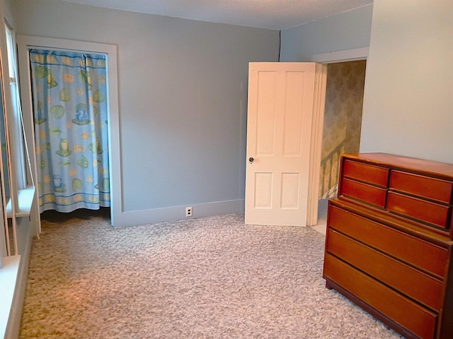 unfurnished bedroom with light carpet and baseboards