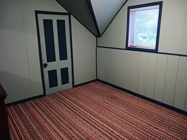 spare room with lofted ceiling and carpet flooring