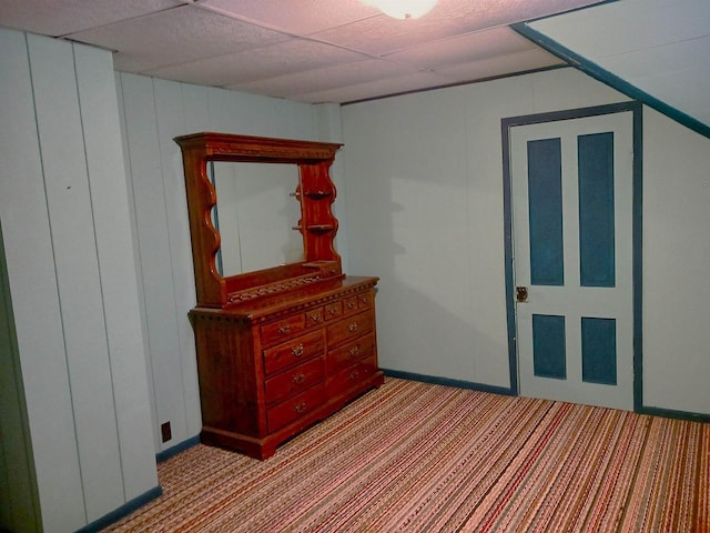 unfurnished bedroom featuring light carpet and a drop ceiling