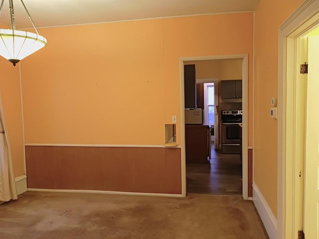 spare room with carpet and wainscoting