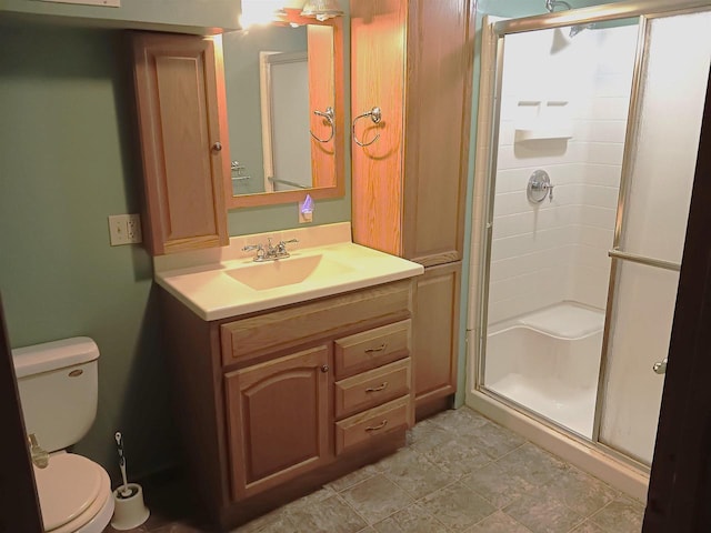 bathroom with a stall shower, vanity, and toilet