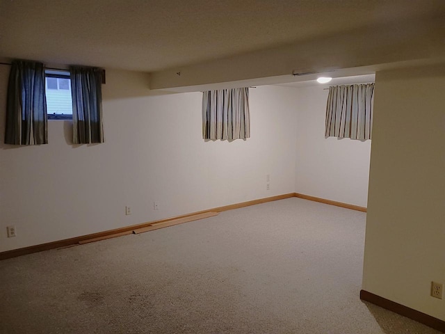 below grade area featuring carpet floors and baseboards