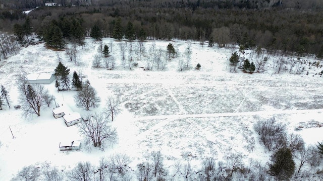 snowy aerial view featuring a forest view