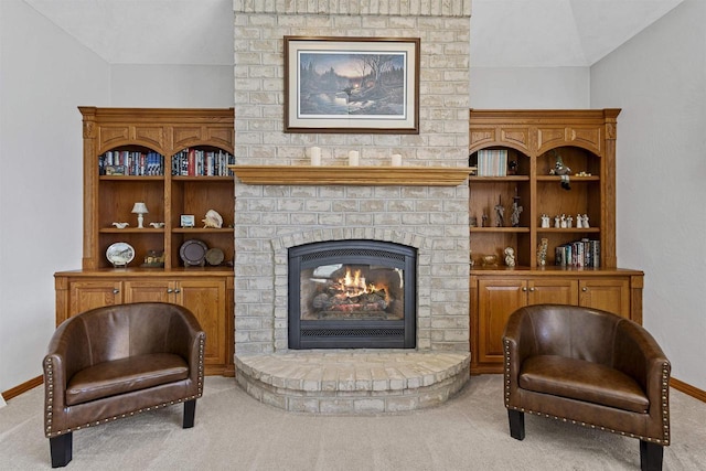 living area featuring carpet, vaulted ceiling, a fireplace, and baseboards