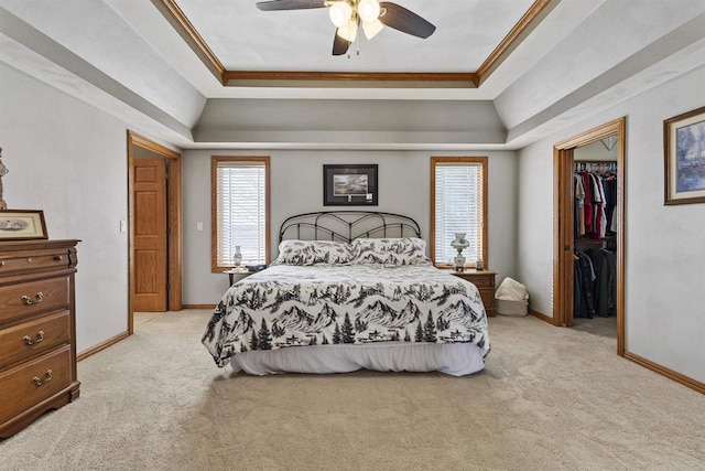 bedroom featuring crown molding, a tray ceiling, and light colored carpet