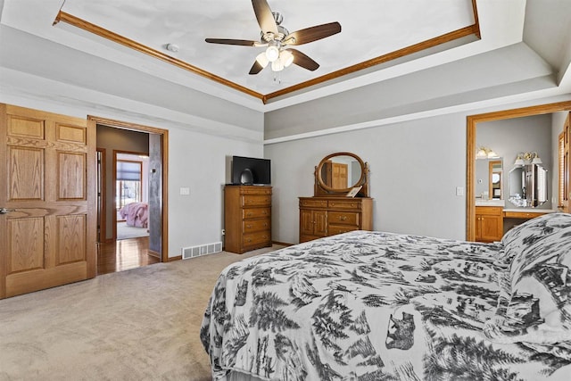 bedroom with light carpet, a raised ceiling, and visible vents