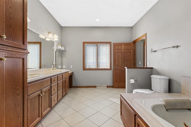 bathroom featuring double vanity, baseboards, visible vents, tile patterned flooring, and a sink