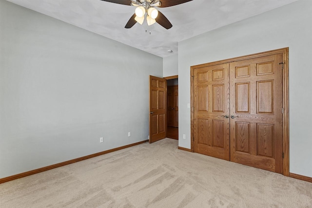 unfurnished bedroom with ceiling fan, baseboards, a closet, and light colored carpet