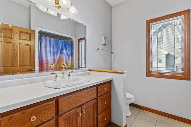 bathroom featuring baseboards, vanity, toilet, and tile patterned floors