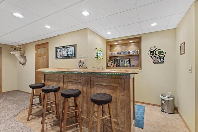 bar featuring a bar, recessed lighting, a drop ceiling, and baseboards