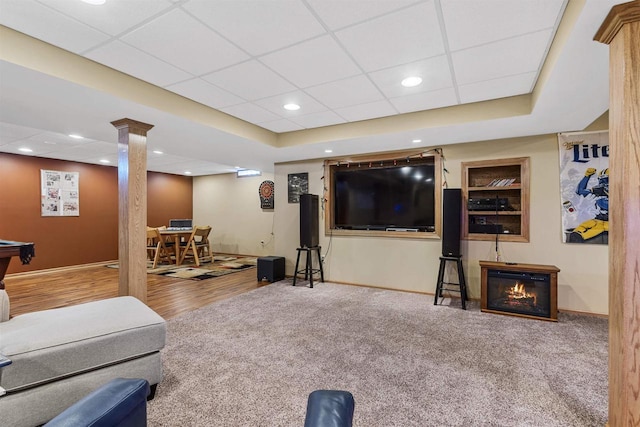 carpeted living room featuring recessed lighting, a drop ceiling, and baseboards