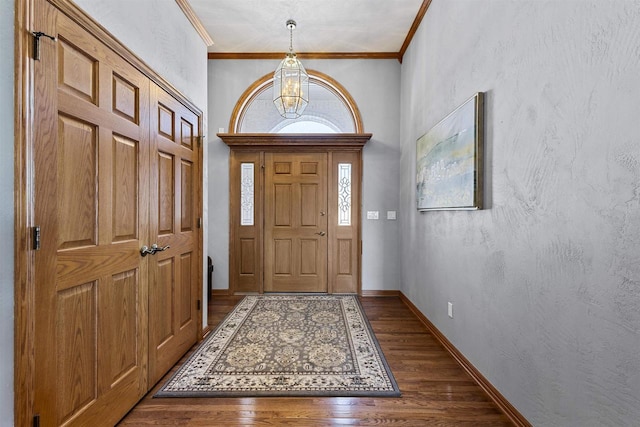 entryway with dark wood-type flooring, a textured wall, crown molding, and baseboards