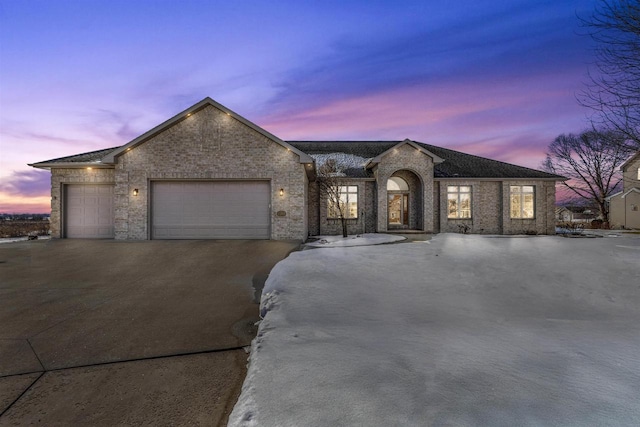 single story home featuring an attached garage, concrete driveway, and brick siding