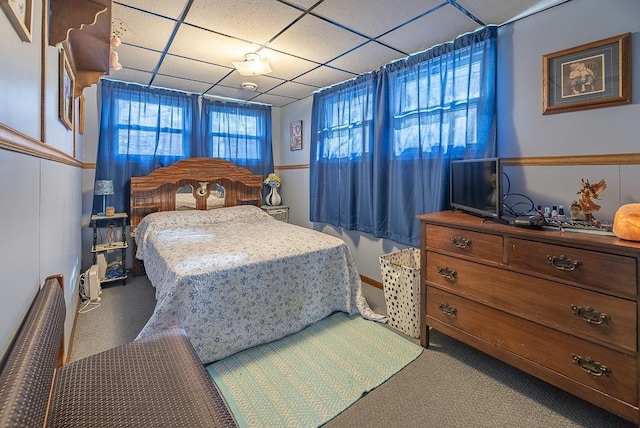 bedroom with carpet floors and a drop ceiling