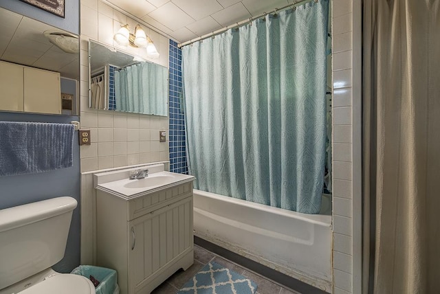 bathroom with tile walls, tasteful backsplash, toilet, shower / bath combo, and vanity