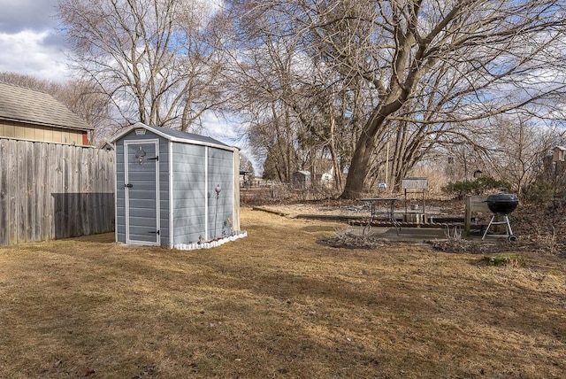 view of yard featuring a storage shed, an outdoor structure, and a fenced backyard