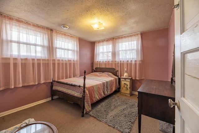 bedroom featuring carpet, baseboards, and a textured ceiling