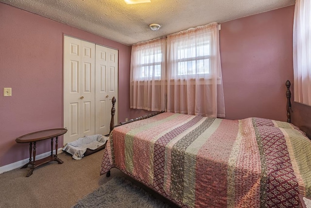 carpeted bedroom featuring a closet, a textured ceiling, and baseboards