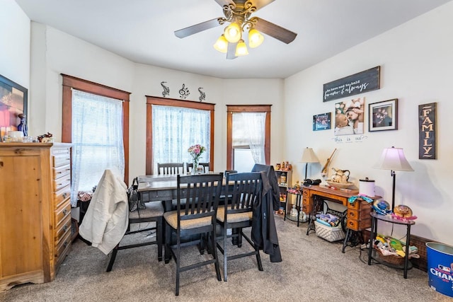 carpeted dining room with a ceiling fan