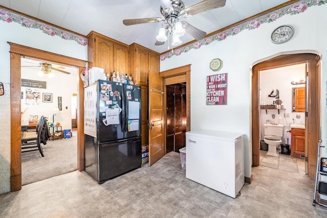 kitchen with refrigerator, brown cabinetry, light countertops, and freestanding refrigerator