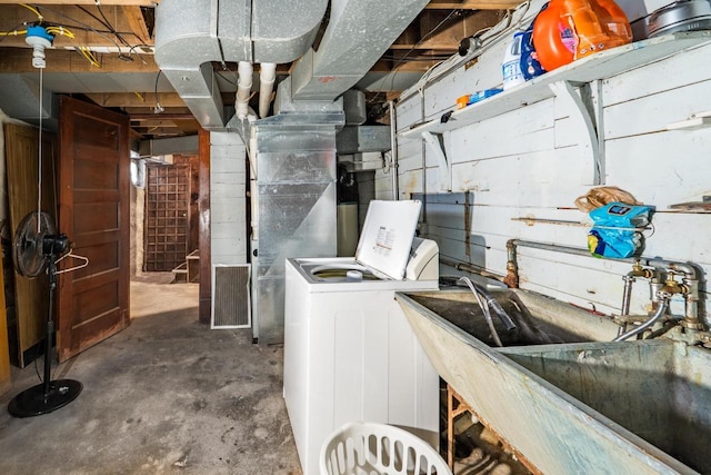 clothes washing area featuring laundry area, washer / clothes dryer, and a sink