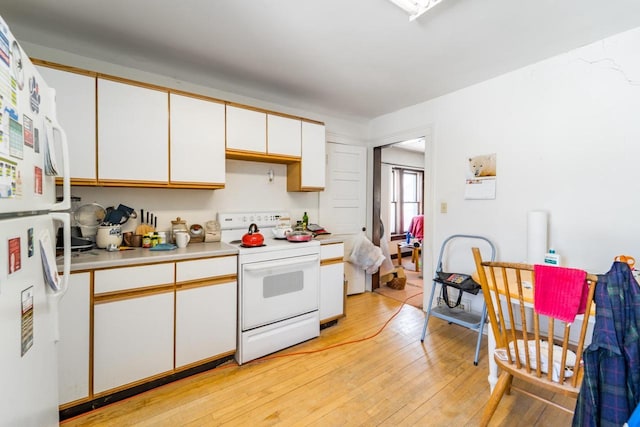 kitchen featuring light countertops, white appliances, light wood-style floors, and white cabinets